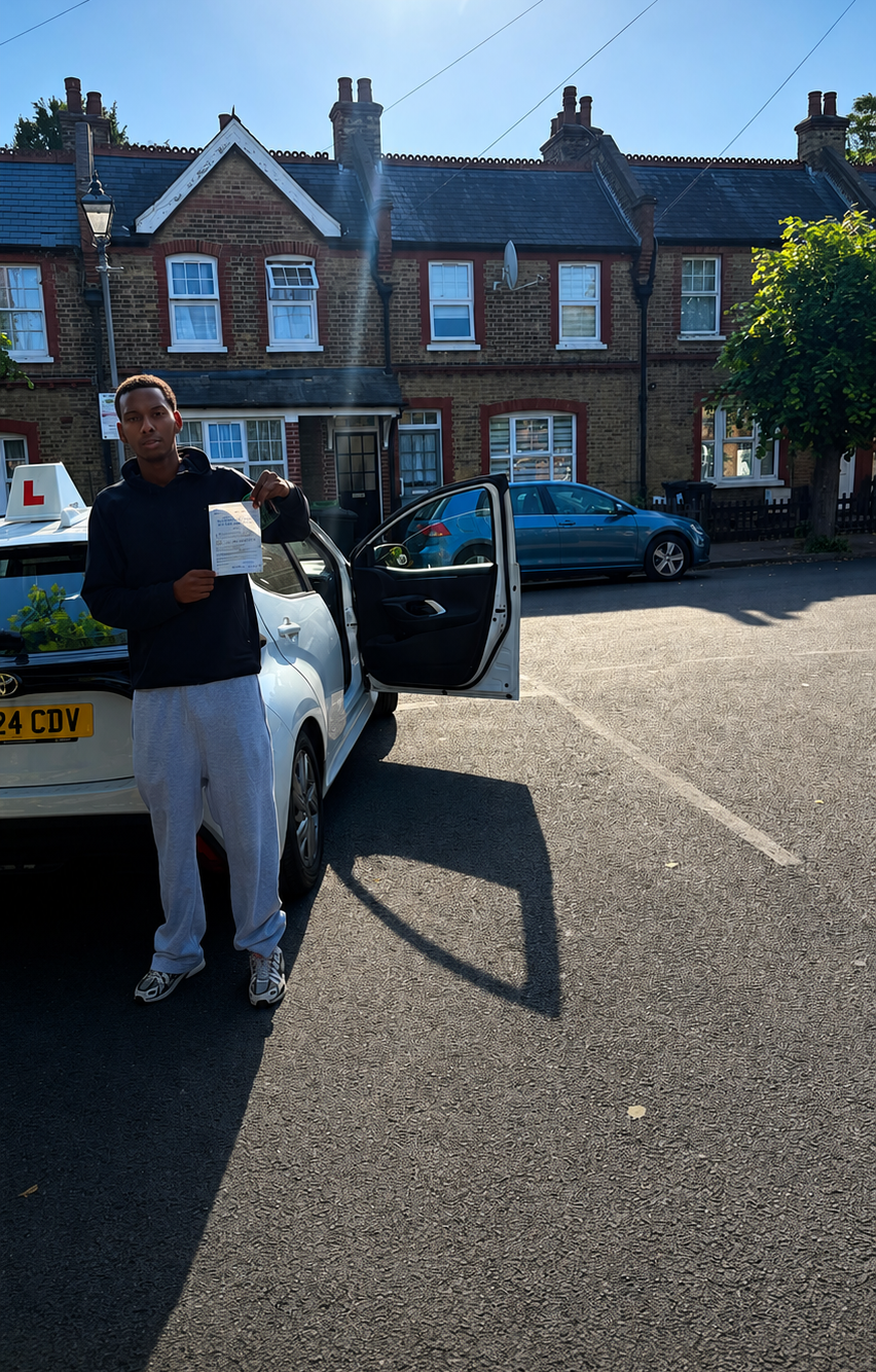 Passed student holding a driving test pass certificate beside a learner car